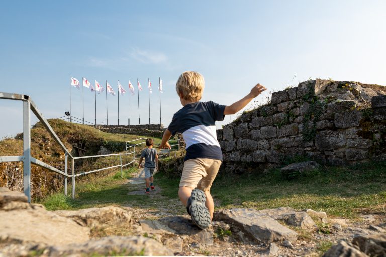 Un enfant court près du Château-fort de Logne.