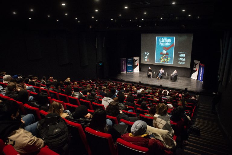 Salle de cinéma et podium avec une table ronde lors du festival PolitiK.