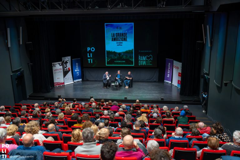 Salle de cinéma et podium avec une table ronde lors du festival PolitiK.