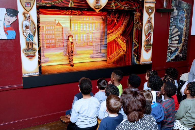 Spectacle de marionnettes, groupe d'enfants qui assiste à la représentation.