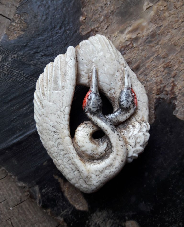 Un pendentif avec des grues.